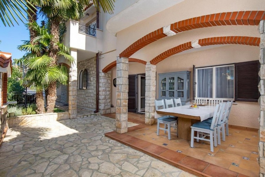 Covered terrace with seating area and natural stone facade