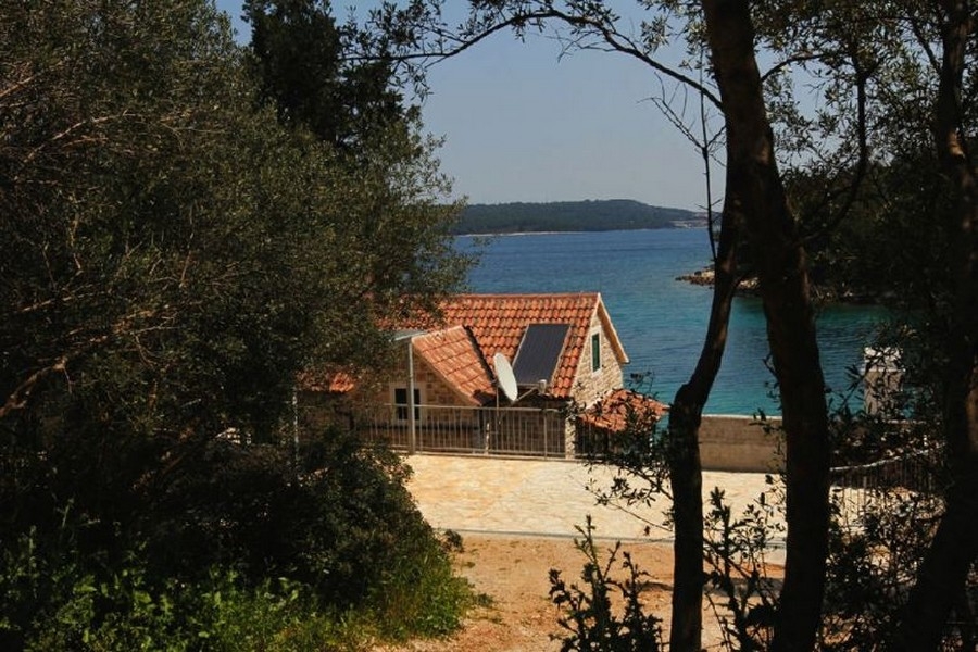 Stone house with sea views between trees