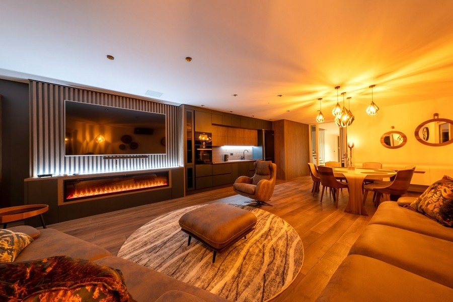 Living area with sofa, fireplace and open kitchen