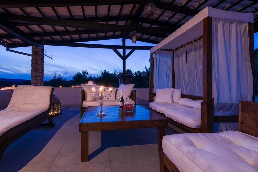 Lounge area with four-poster bed and coastal views