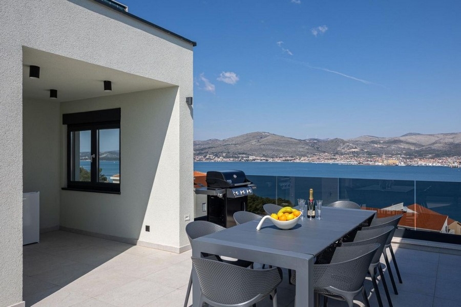 Covered terrace with dining area and sea views