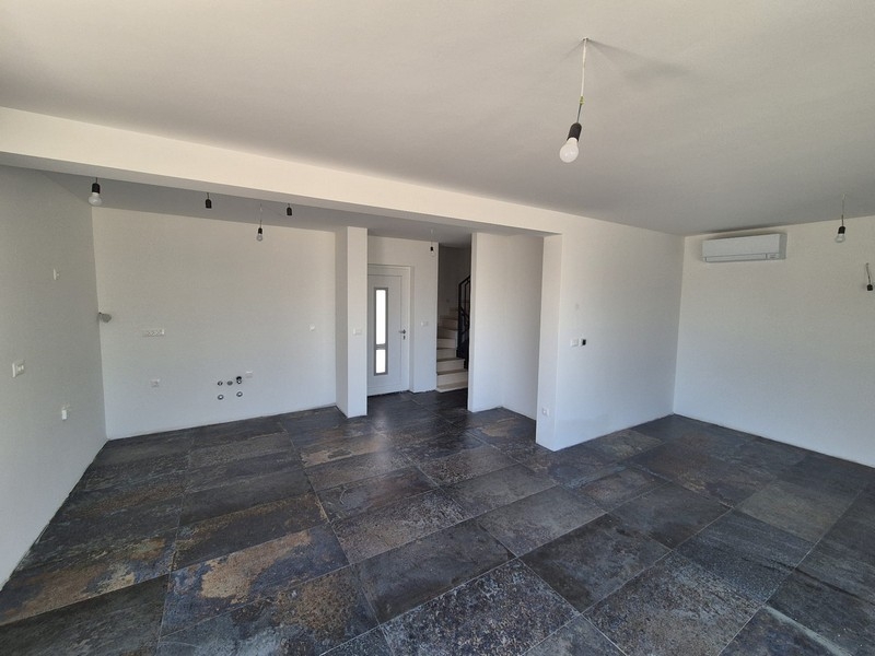 Open-plan living area with large tiles and integrated air conditioning.