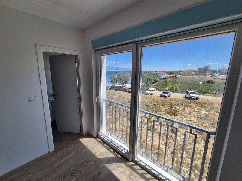 Bedroom with large windows and access to a balcony with sea views.