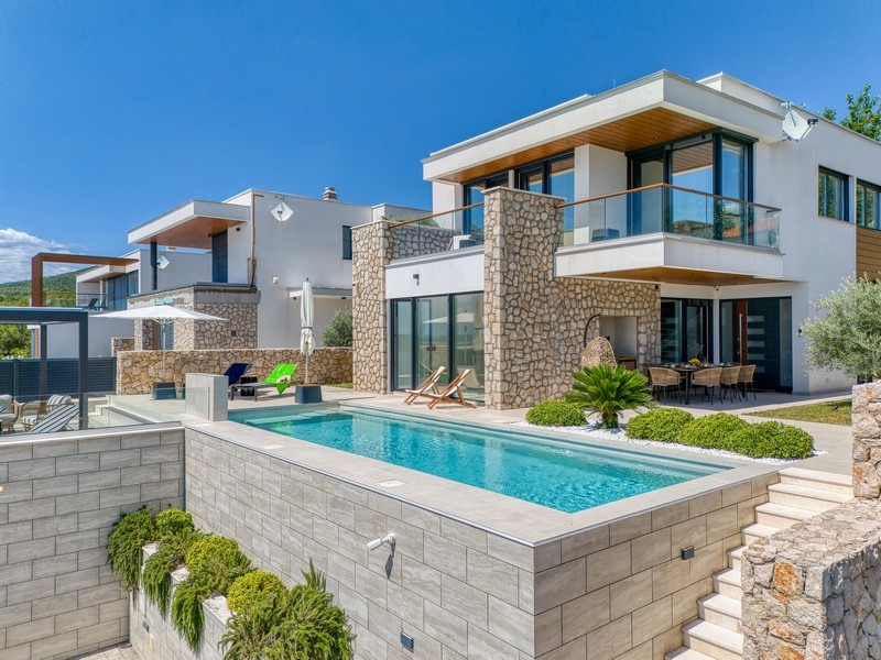 Luxury villa with pool, natural stone facade and terrace by the sea