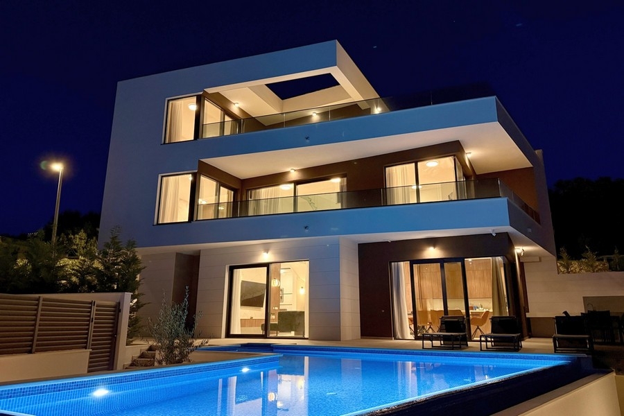Luxury villa with swimming pool and illuminated facade in the evening