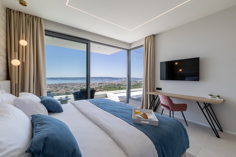 Modern bedroom with glass front and coastal panorama