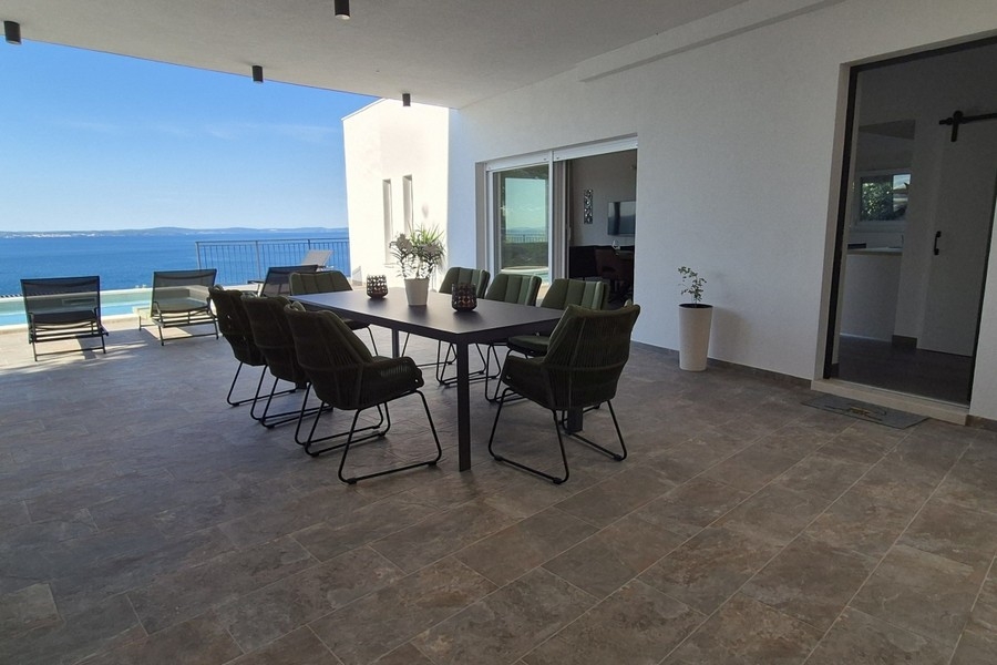 Spacious terrace with pool and lounge area by the sea