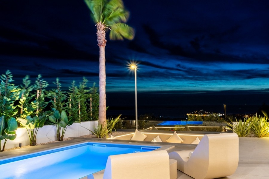 Illuminated pool area at night with sea views