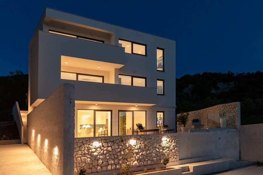 Modern villa at night with pool
