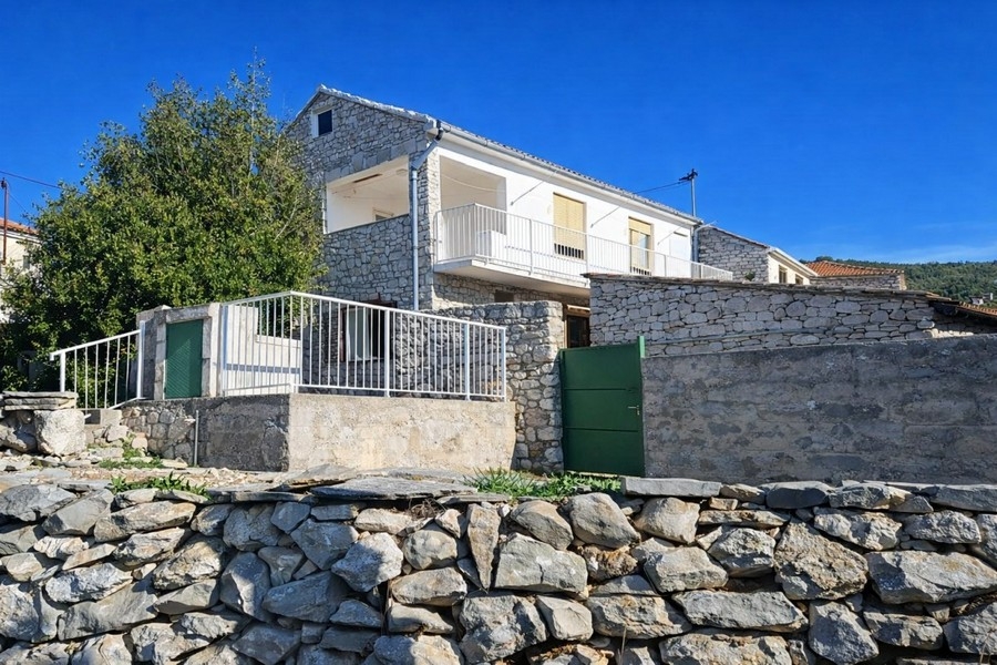 Exterior view of stone house with stone wall