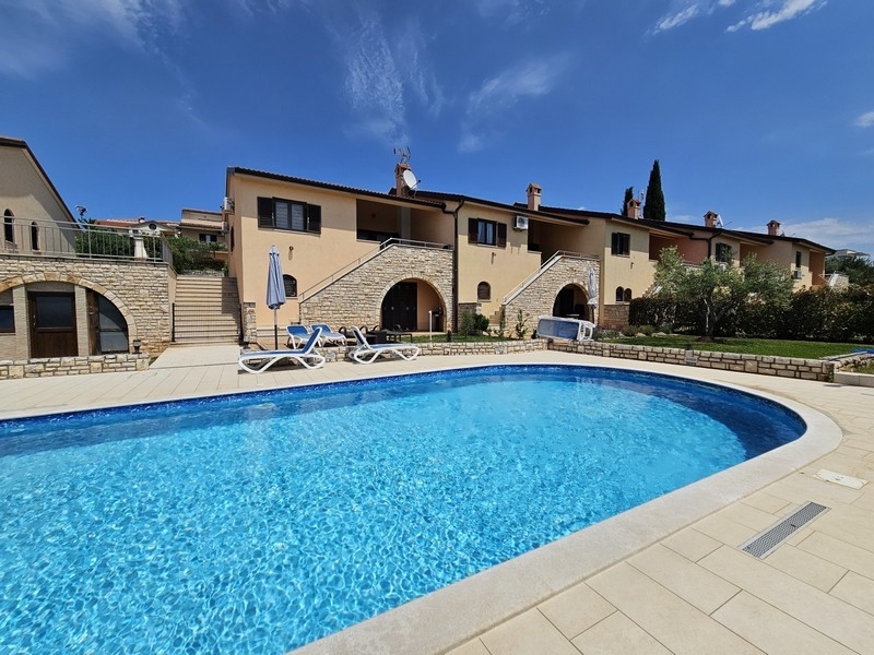 Community pool with sunbathing area and residential complex near Porec
