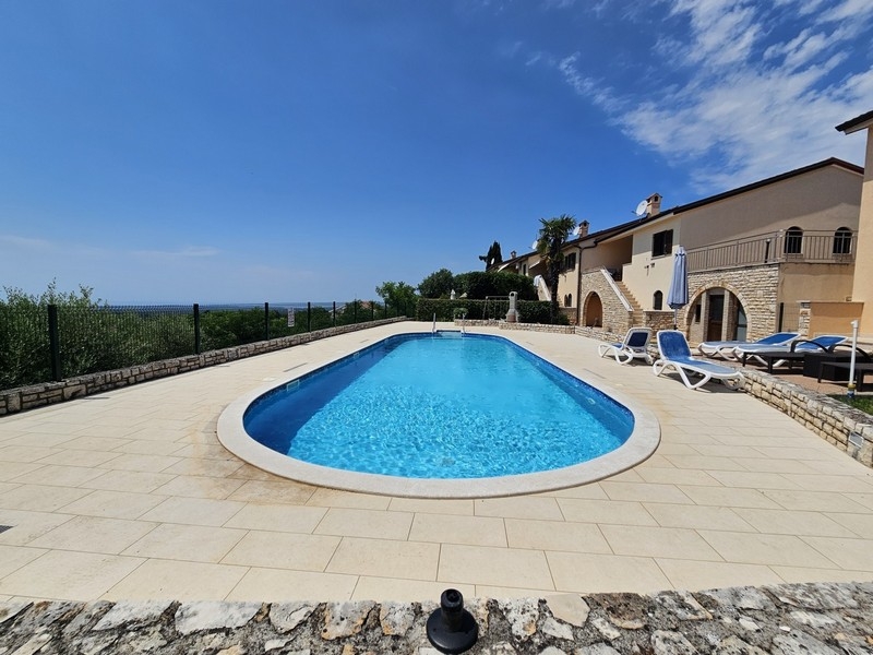 Tiled pool area with terrace and residential complex
