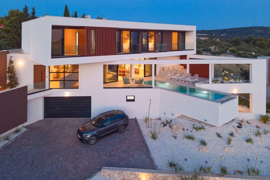 Illuminated villa with pool in the evening