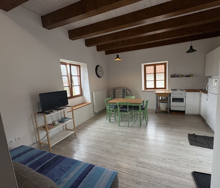 Living room with wooden beamed ceiling and kitchen
