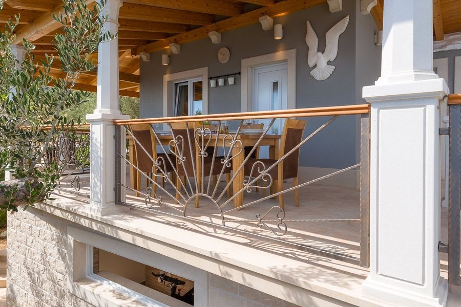 Covered terrace with railings on the house