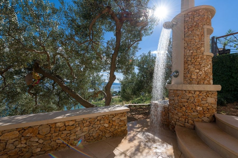Outdoor shower on a stone wall in the garden