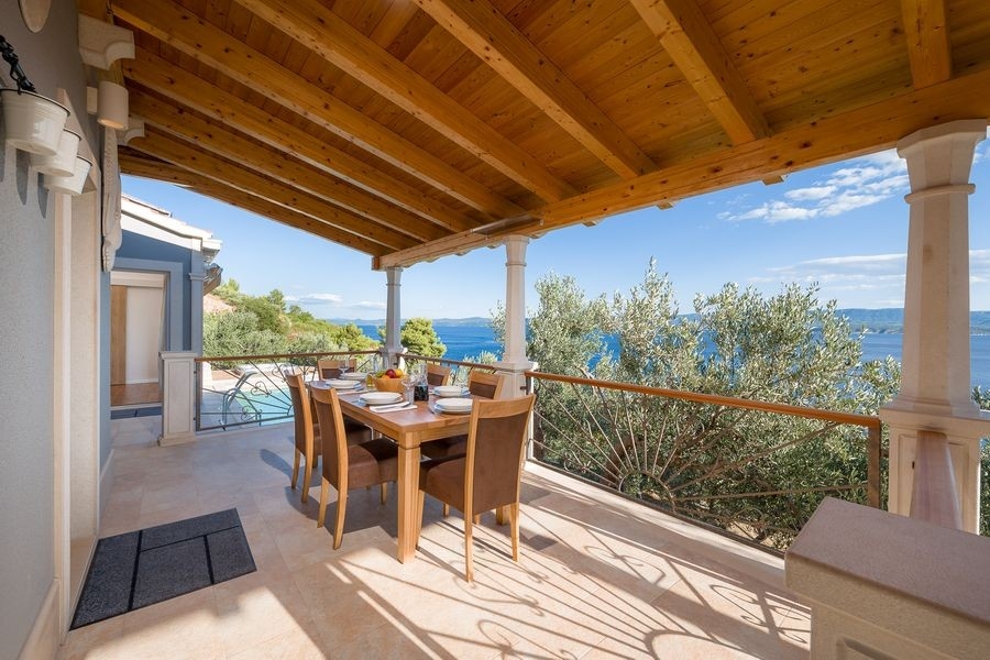 Covered terrace with a set table and sea views