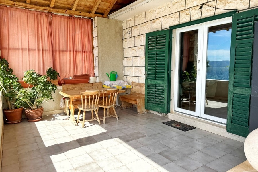 Covered terrace with seating and sea views