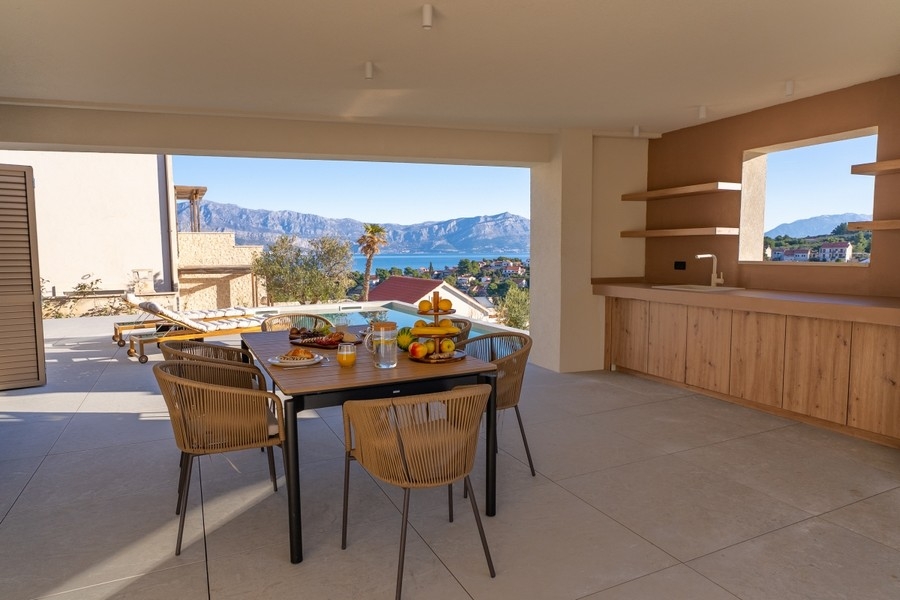 Covered terrace with dining area and outdoor kitchen