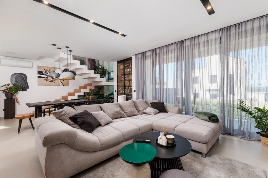 Open living area with sofa and stairs