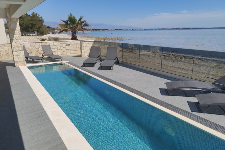 Pool with sun loungers right by the sea on the island of Vir