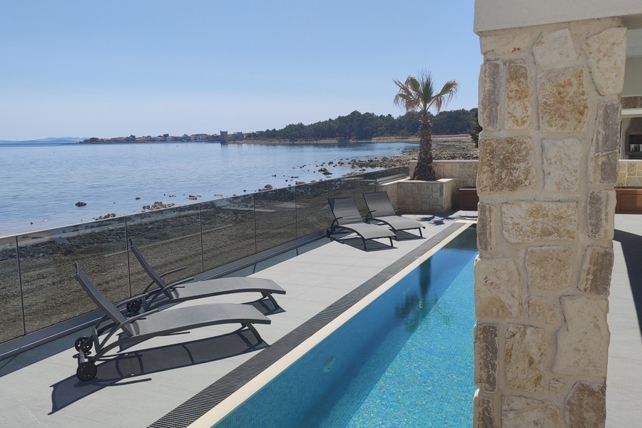 Sun loungers by the pool overlooking the sea