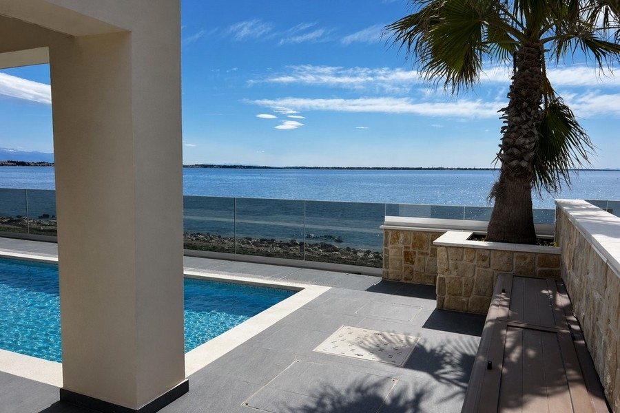 Pool area with palm tree and sea view