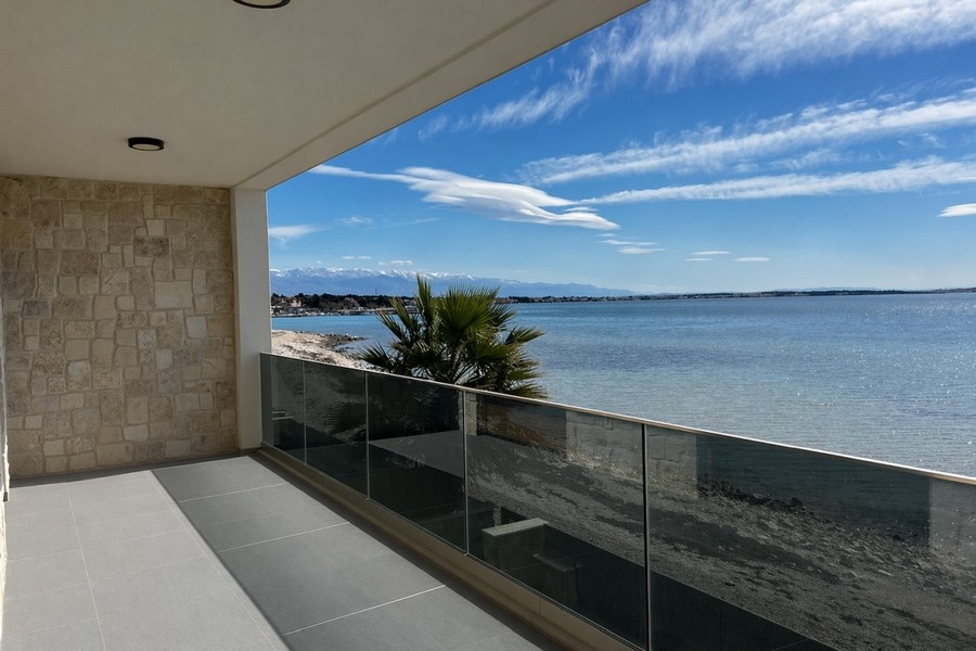 Covered terrace with glass railings and sea views