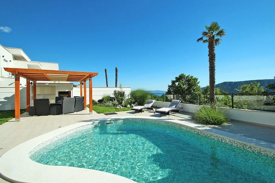Pool with pergola and view of the green surroundings
