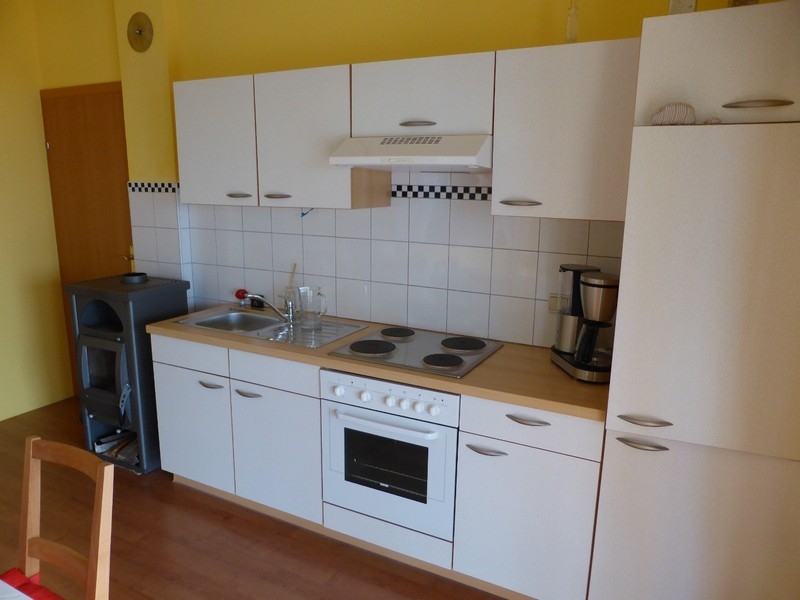 Kitchen with stove and built-in cupboards