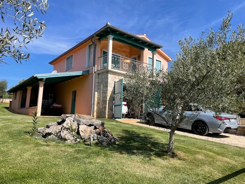 House view with covered parking space and garden
