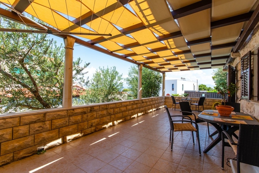 Covered terrace with stone walls and sea views