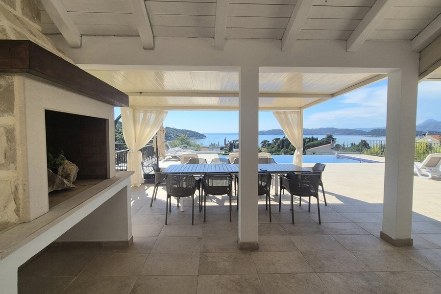 Covered terrace with fireplace and dining table