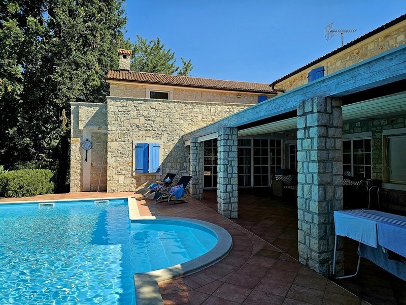 Swimming pool with sun loungers on the covered terrace