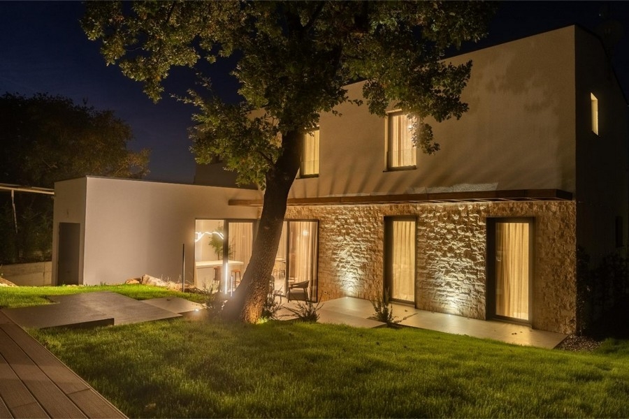 Illuminated villa with stone facade at night