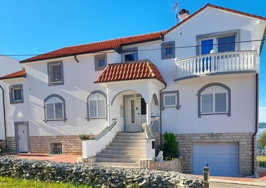 Front view with entrance stairs and garage