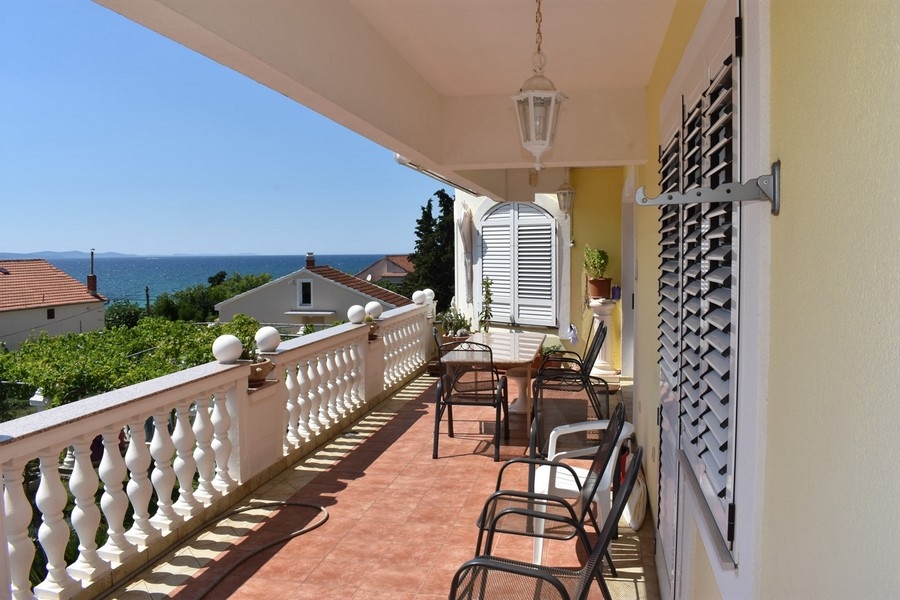 Covered terrace with seating area and sea views