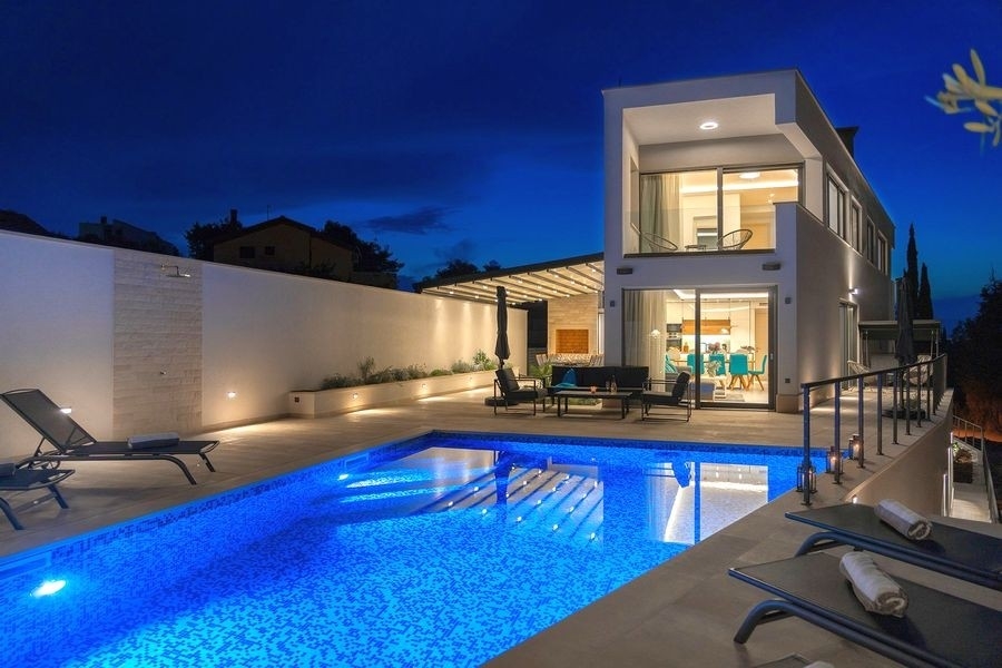 Modern villa with illuminated pool in the evening on Brac