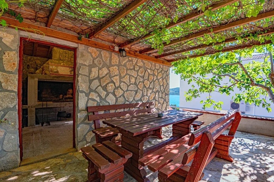 Covered summer kitchen with grill and wooden table