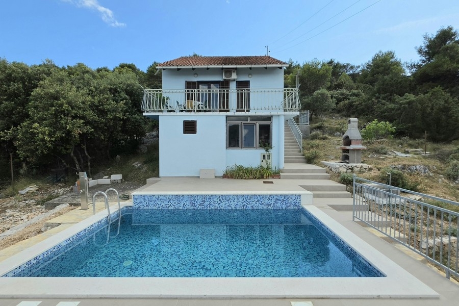 Exterior view of the house with pool and garden