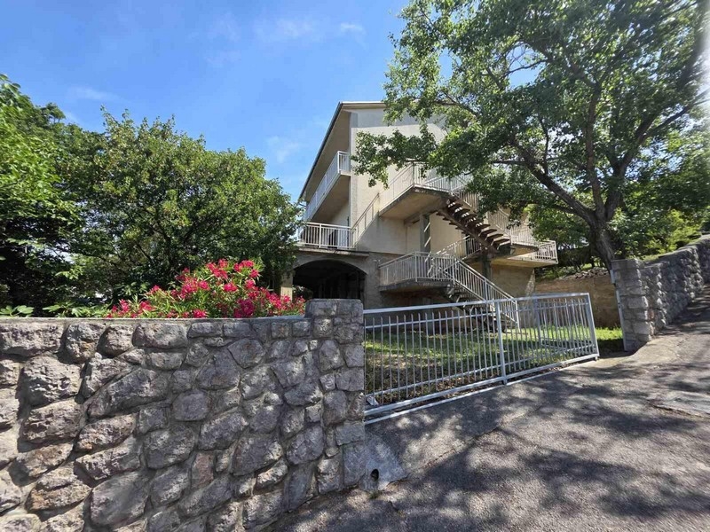 House entrance with stone wall and garden