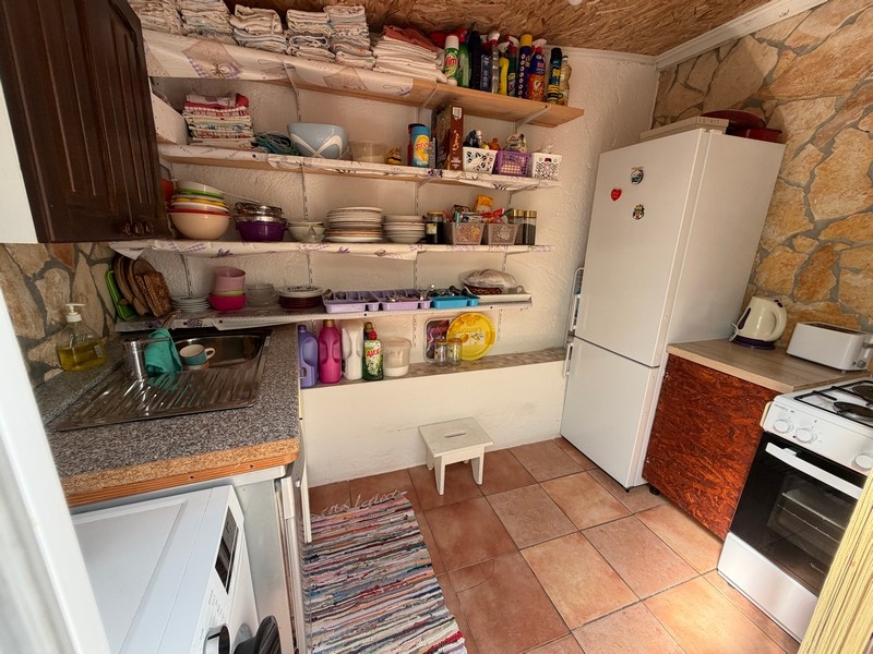 Summer kitchen with refrigerator and shelves