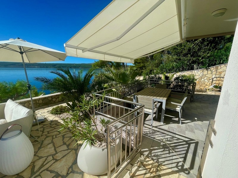 Covered terrace with dining table and sea view