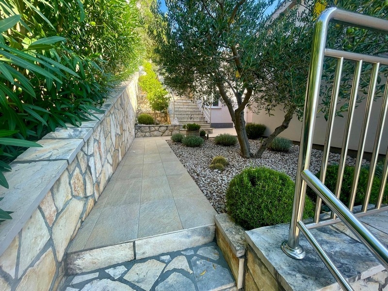 Paved path with natural stone wall and olive tree