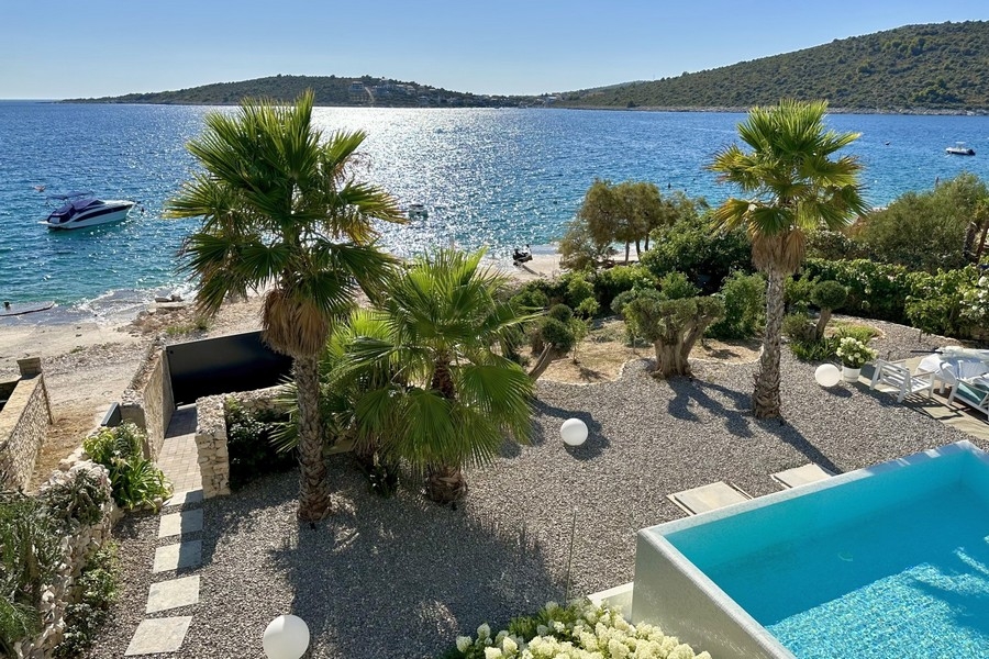 Beach and sea directly in front of the villa with pool and palm garden
