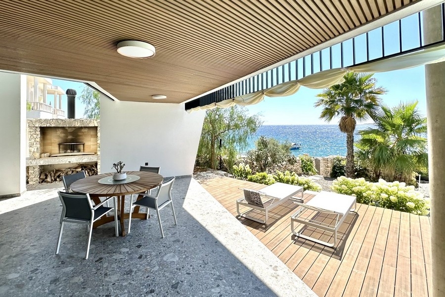 Covered terrace with seating area and sea views