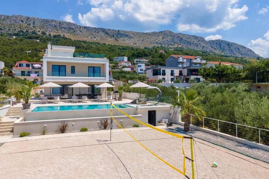 Villa with pool in front of a mountain backdrop