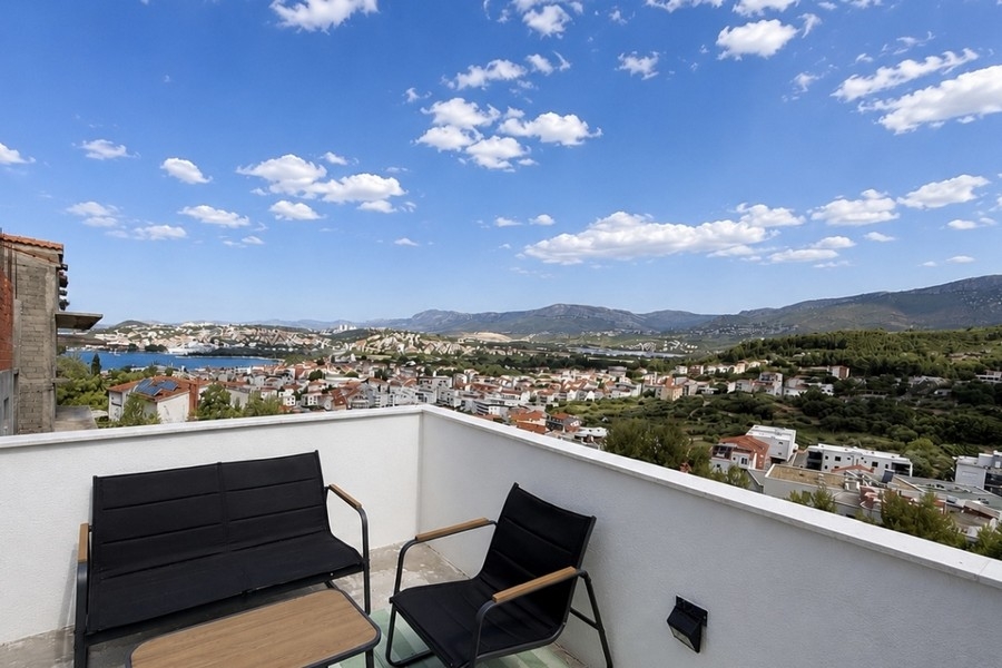 Terrace with seating area and view of the town and sea