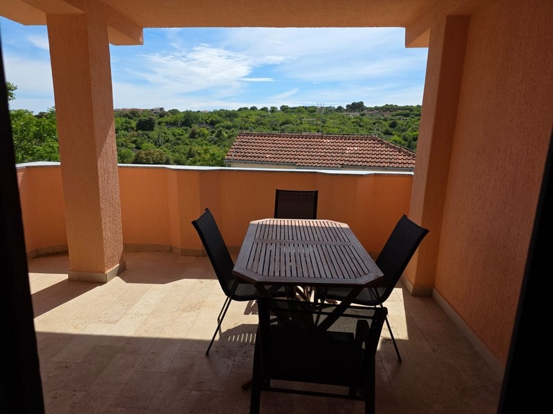 Covered terrace with seating area and view of the countryside