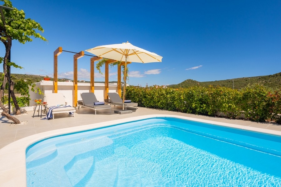Swimming pool with sun loungers and pergola